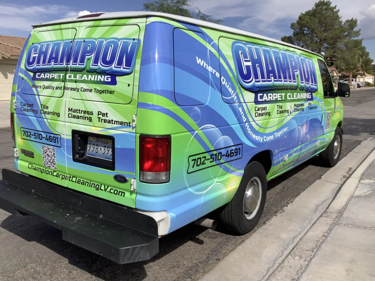 A champion carpet cleaning van is parked on the side of the road.