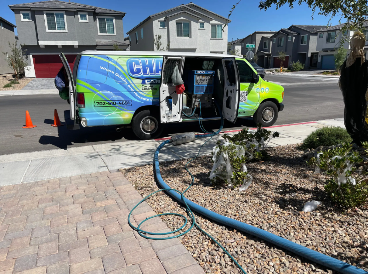 A green and blue van is parked on the side of the road