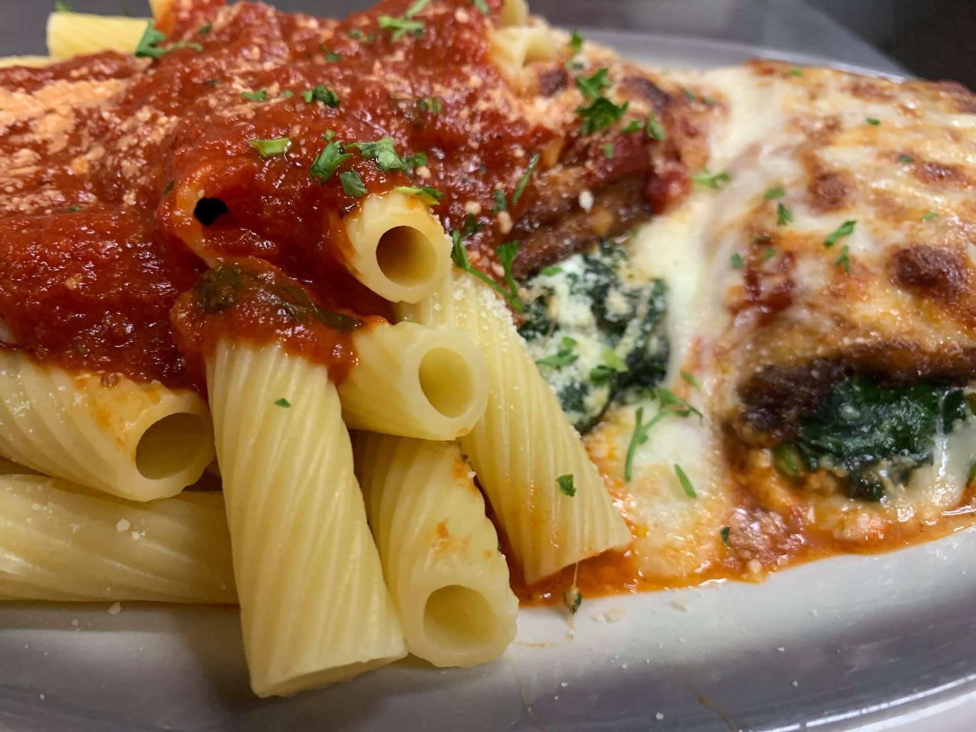 A close up of a plate of pasta and meat on a table.
