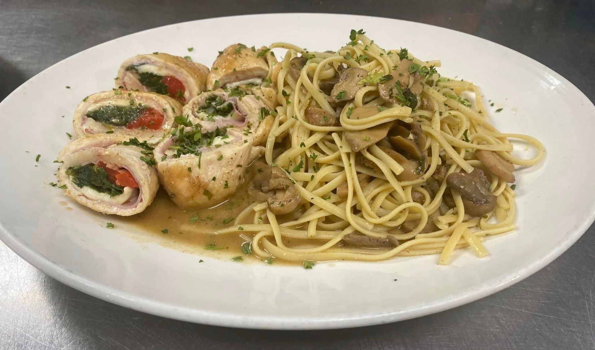 A white plate topped with noodles and chicken on a table.