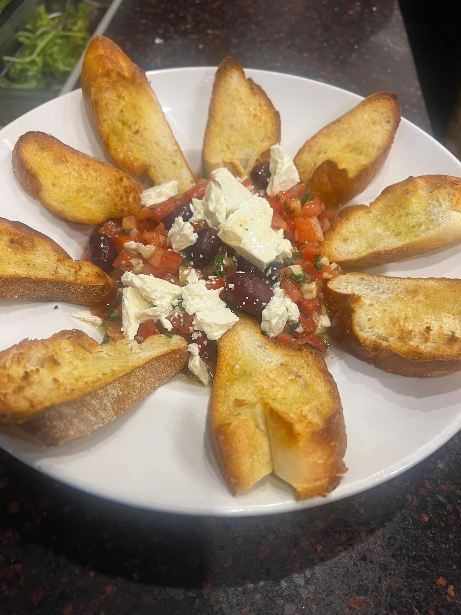 A white plate topped with bread and vegetables on a table.