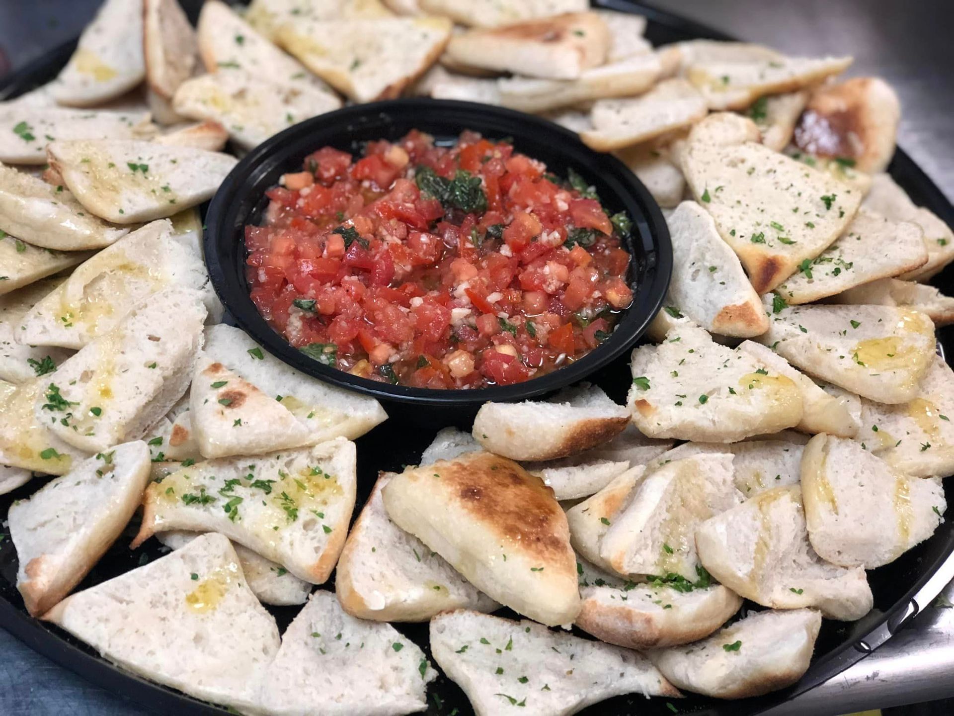 A tray of food with a bowl of salsa on top of it.