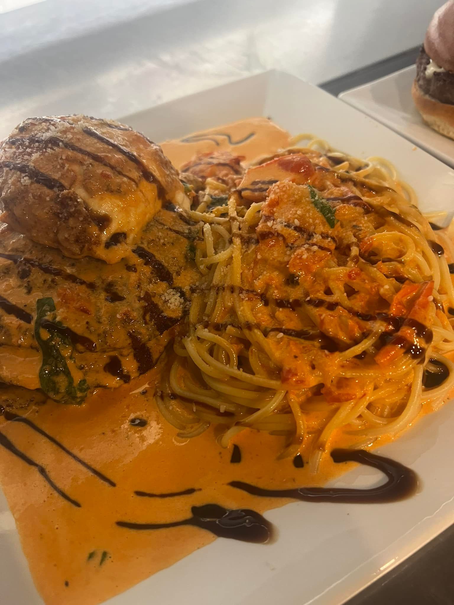 A close up of a plate of food with spaghetti and meat on a table.