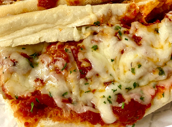 A close up of a sandwich with tomato sauce and cheese on a plate.