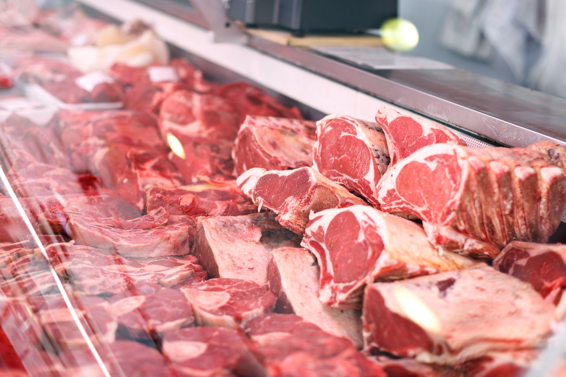 Tagli freschi di carne rossa esposti in una vetrina di macelleria, pronti per la vendita.