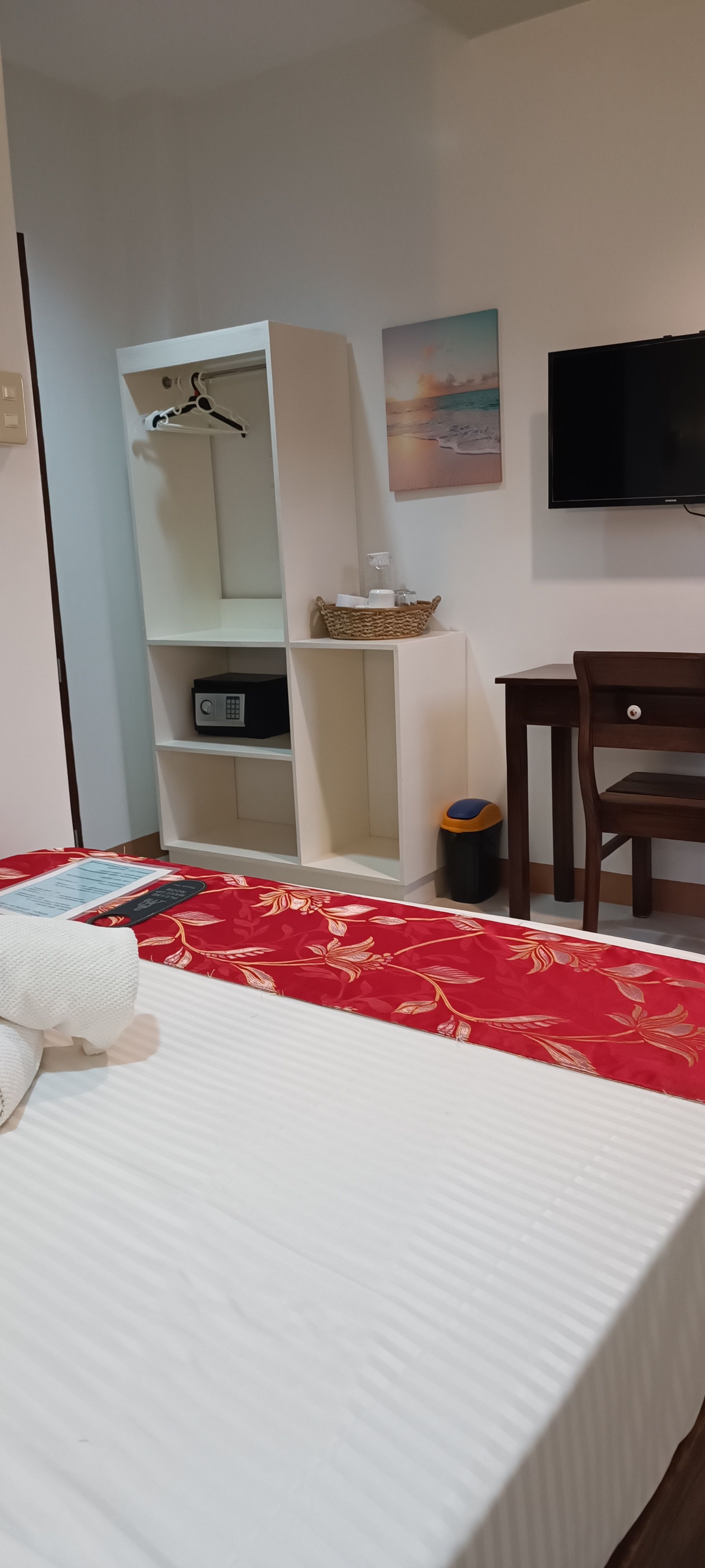 A hotel room with a bed , desk , and television.