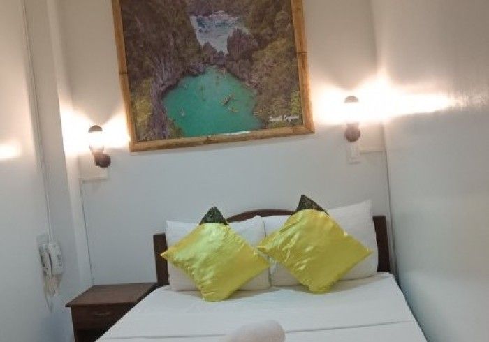 A bedroom with a bed and a painting on the wall