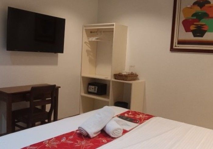 A hotel room with a bed and a flat screen tv