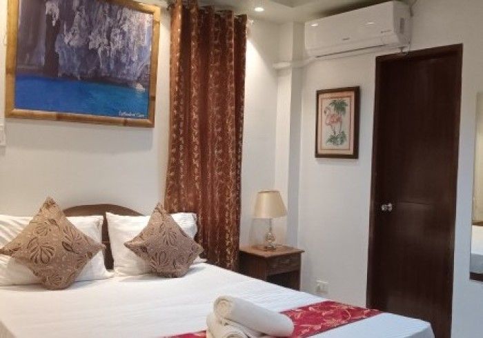 A hotel room with a bed and a picture on the wall