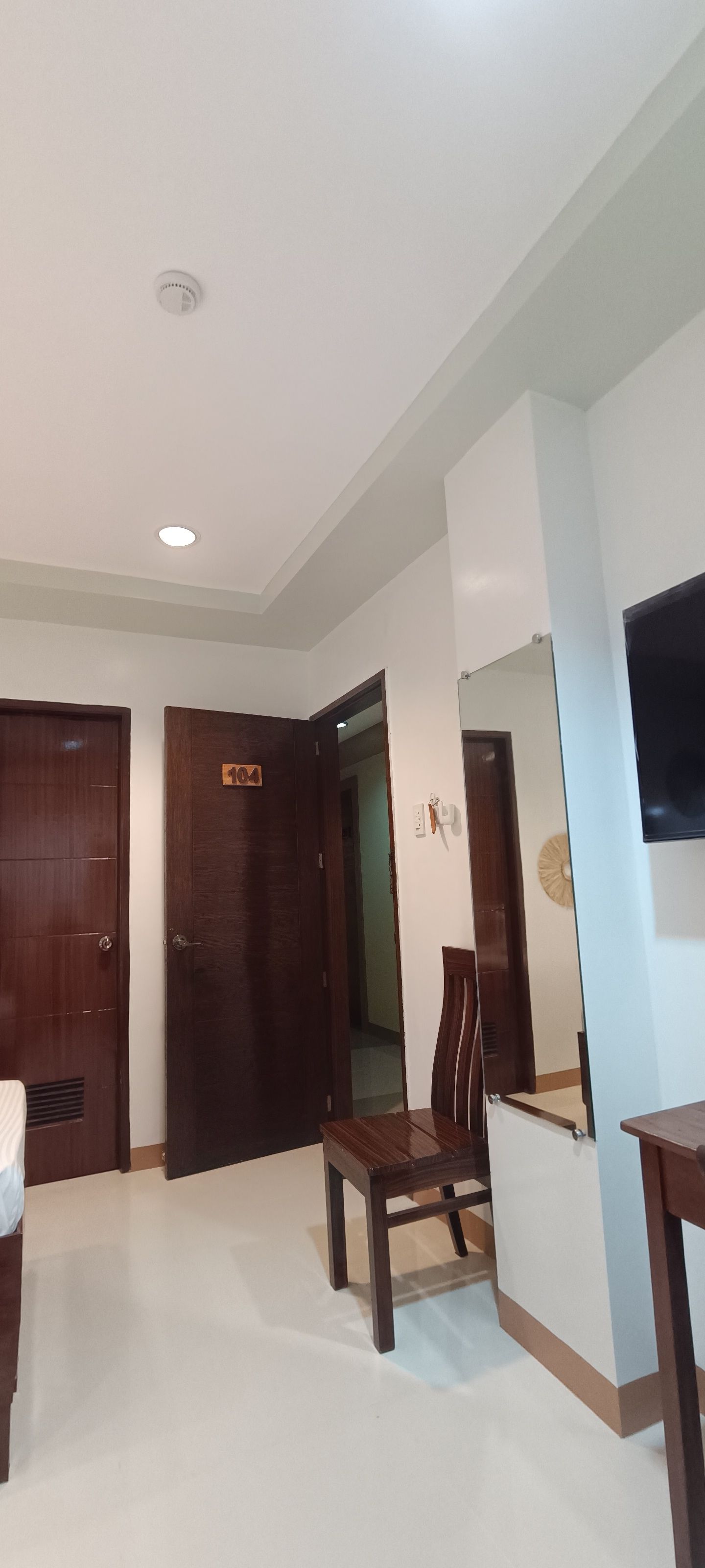 A hotel room with a table and chairs and a television.