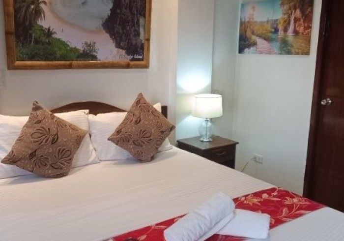 A bedroom with a bed and a picture on the wall above it