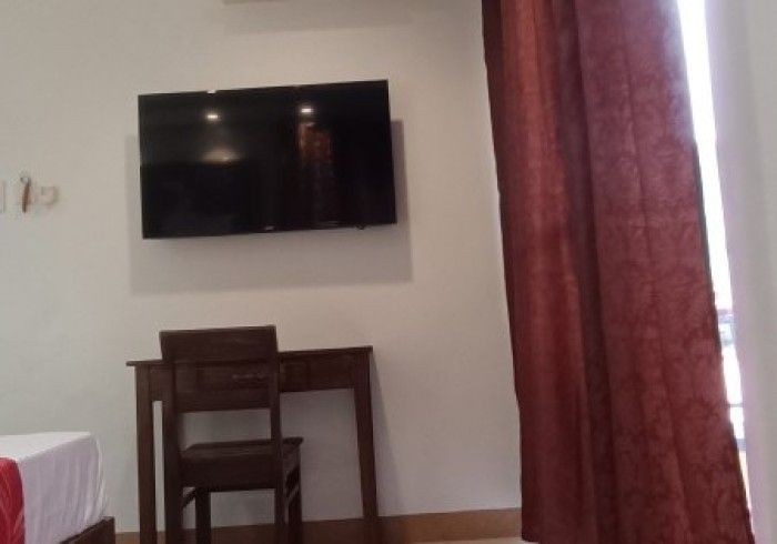 A hotel room with a flat screen tv on the wall