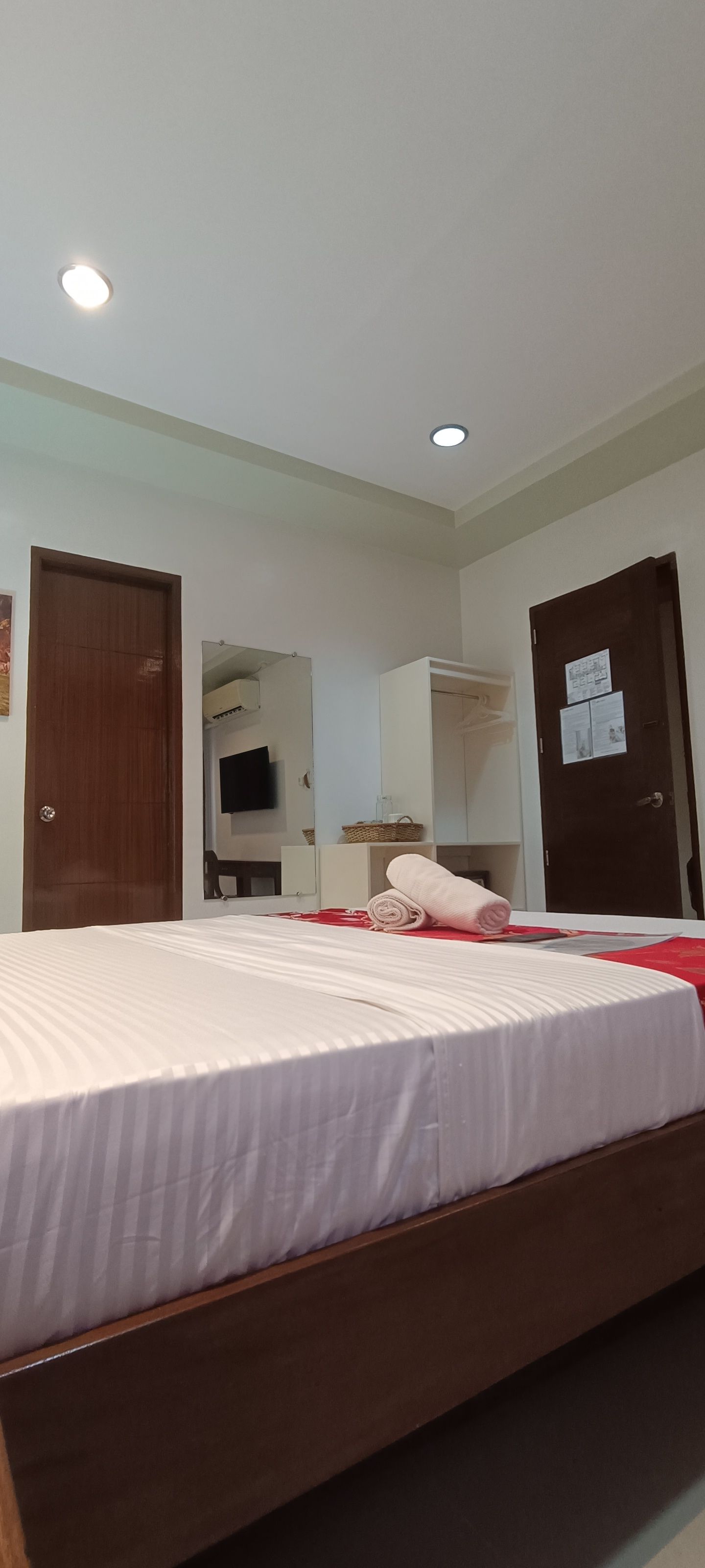 A hotel room with a large bed and a door.