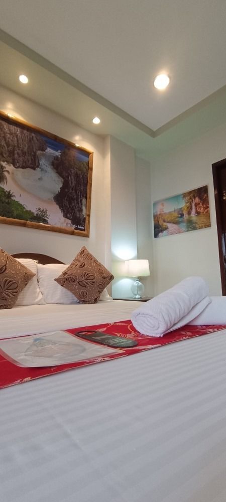 There is a painting on the wall above the bed in the room.