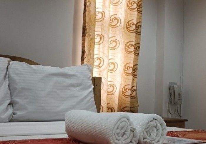 A hotel room with a bed and two towels on it