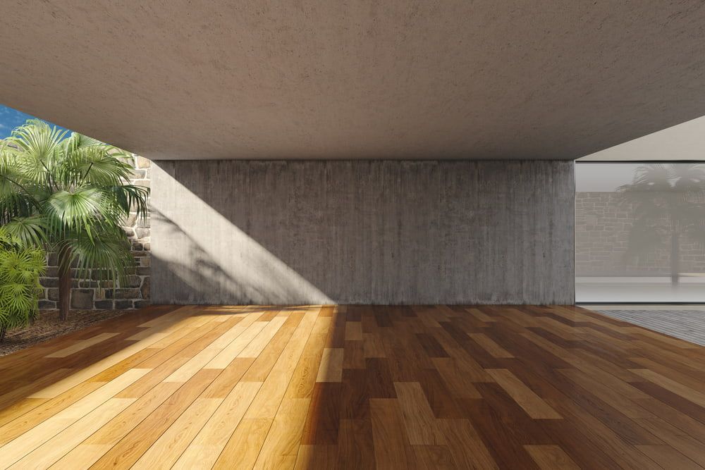 An Empty Room with A Wooden Floor and A Concrete Wall — Budget Timbers in North Lismore, NSW