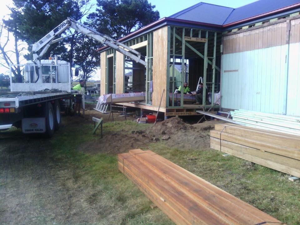 A Truck with A Crane on Top of It Is Parked in Front of A House Under Construction — Budget Timbers in North Lismore, NSW