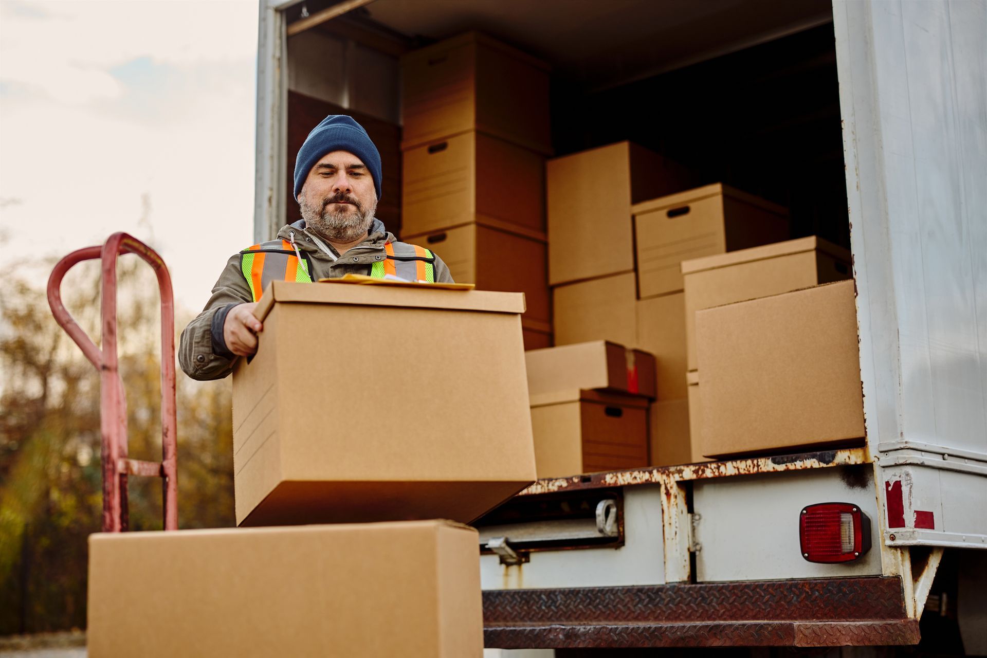 A man is loading boxes into a moving truck.