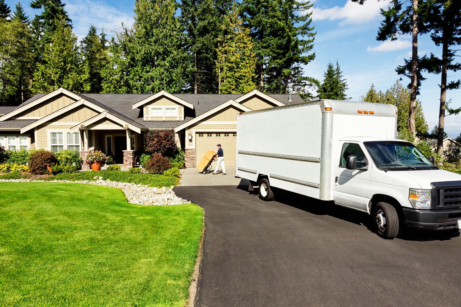 A moving truck is parked in front of a house.