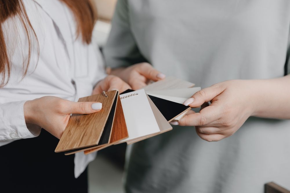 Two people holding and looking at paint and wood swatches.
