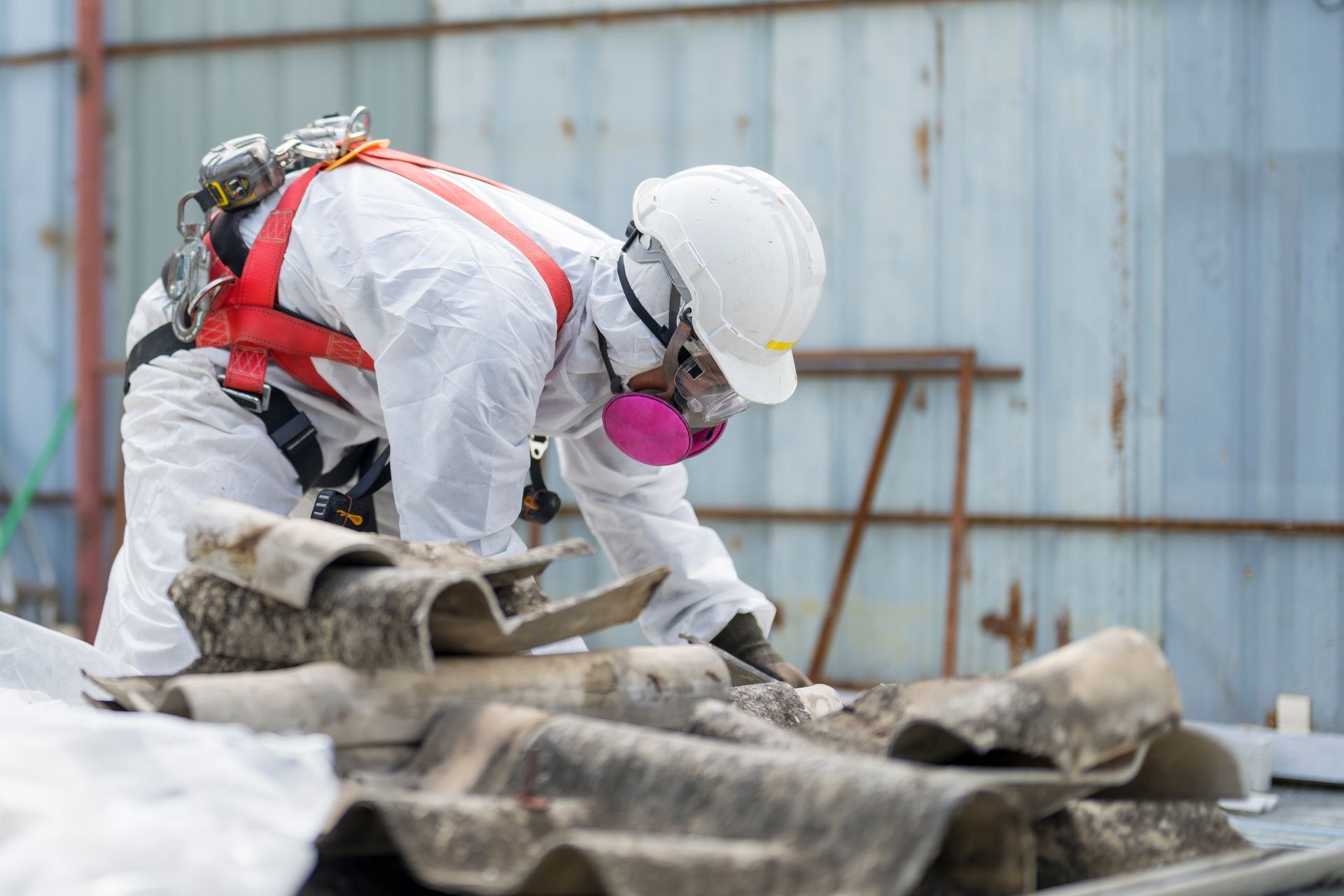 Person in hazmat suit inspecting roofing materials.