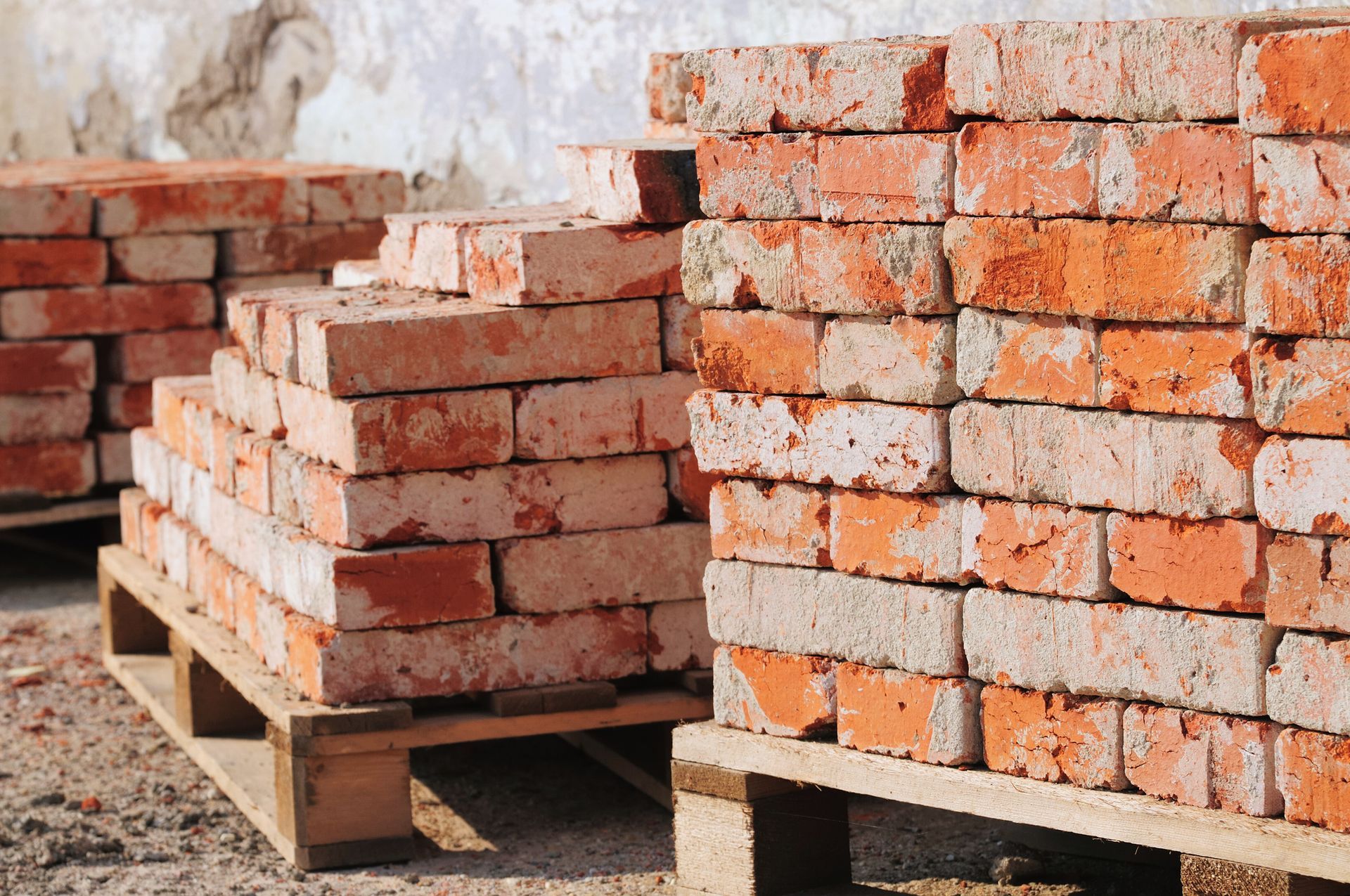 Stacks of red bricks on wooden pallets.