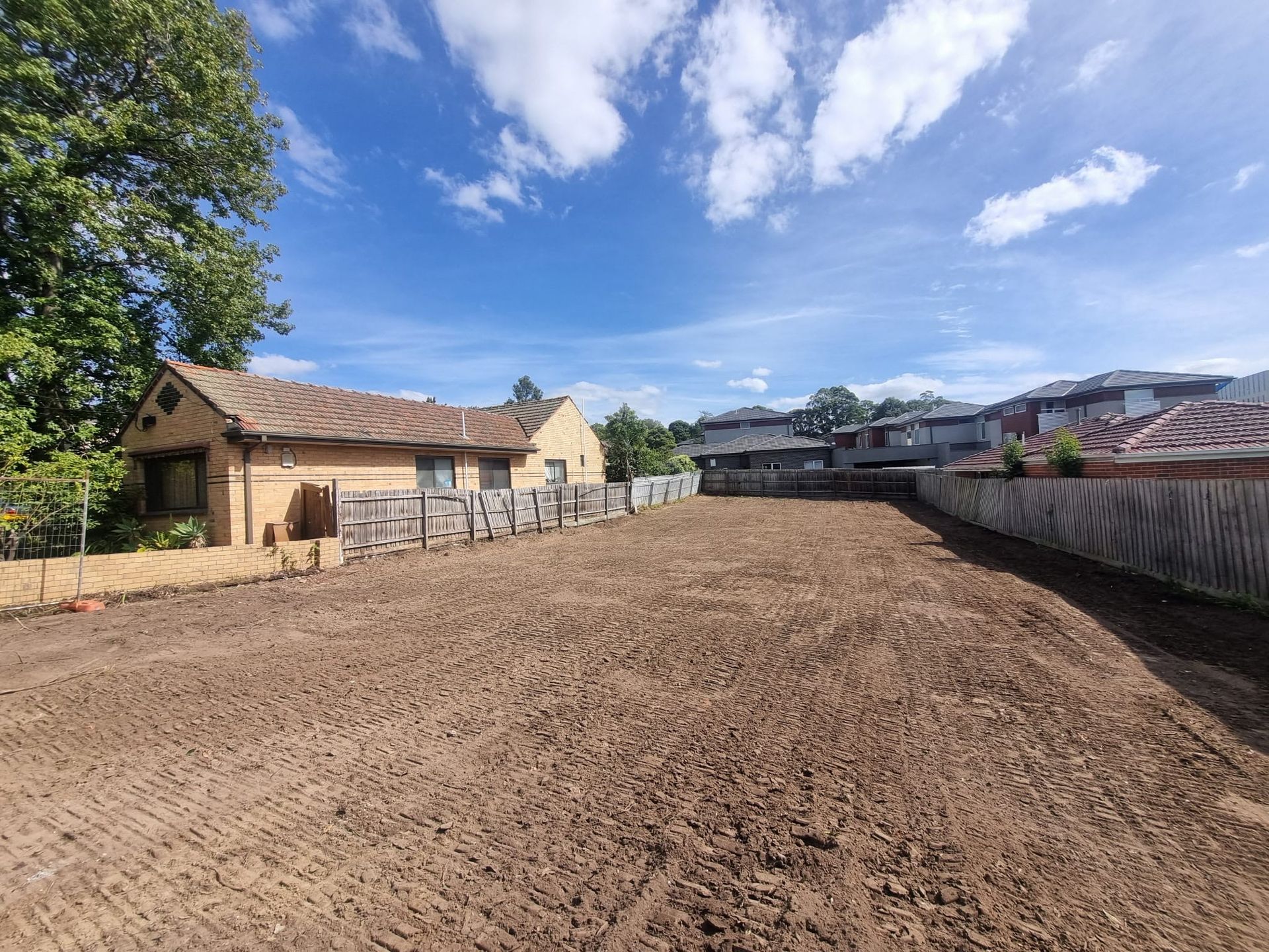 Old window frames lean against a brick building, behind red and white barrier tape.