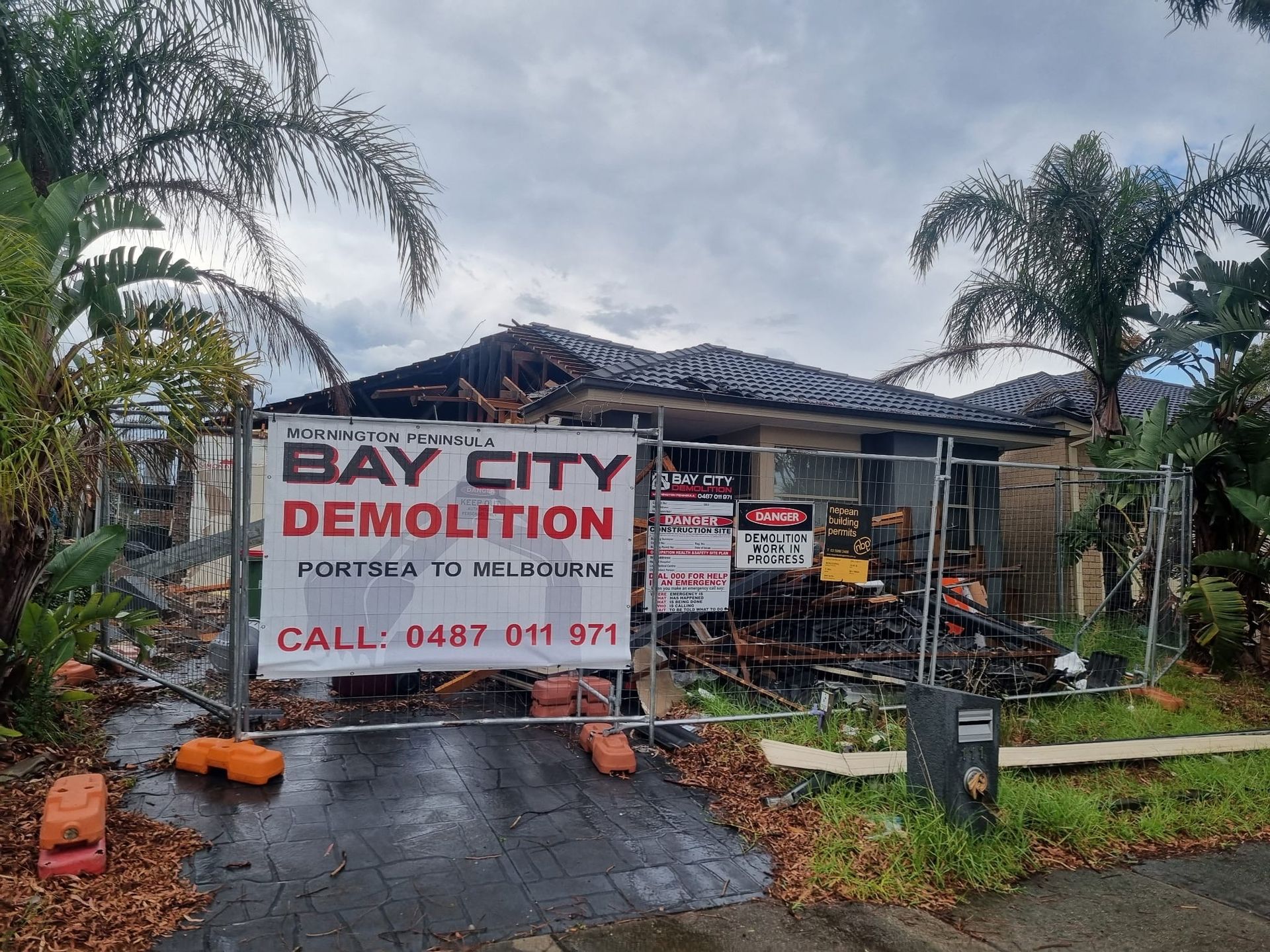 Old window frames lean against a brick building, behind red and white barrier tape.