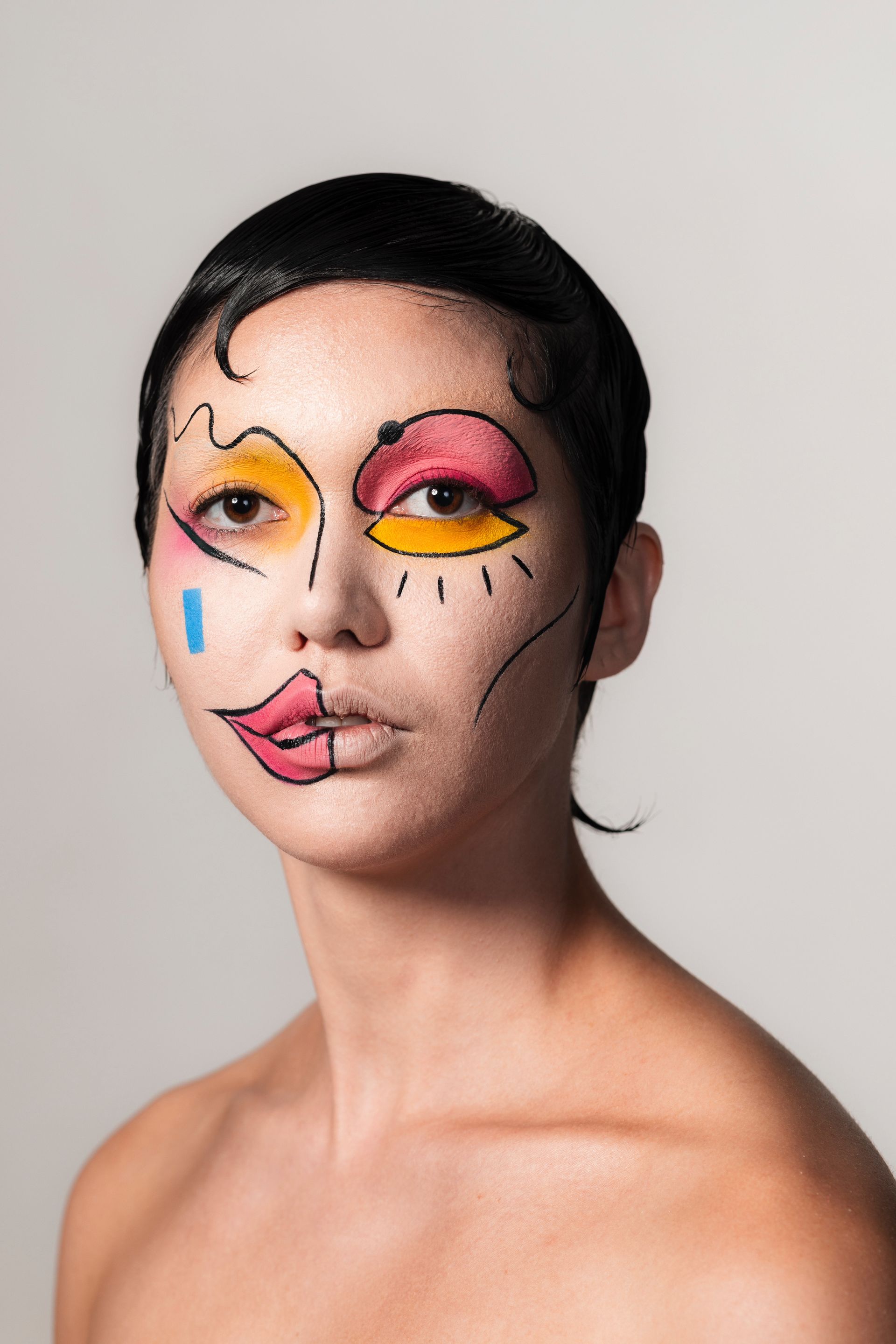 A woman with a colorful face painted on her face.
