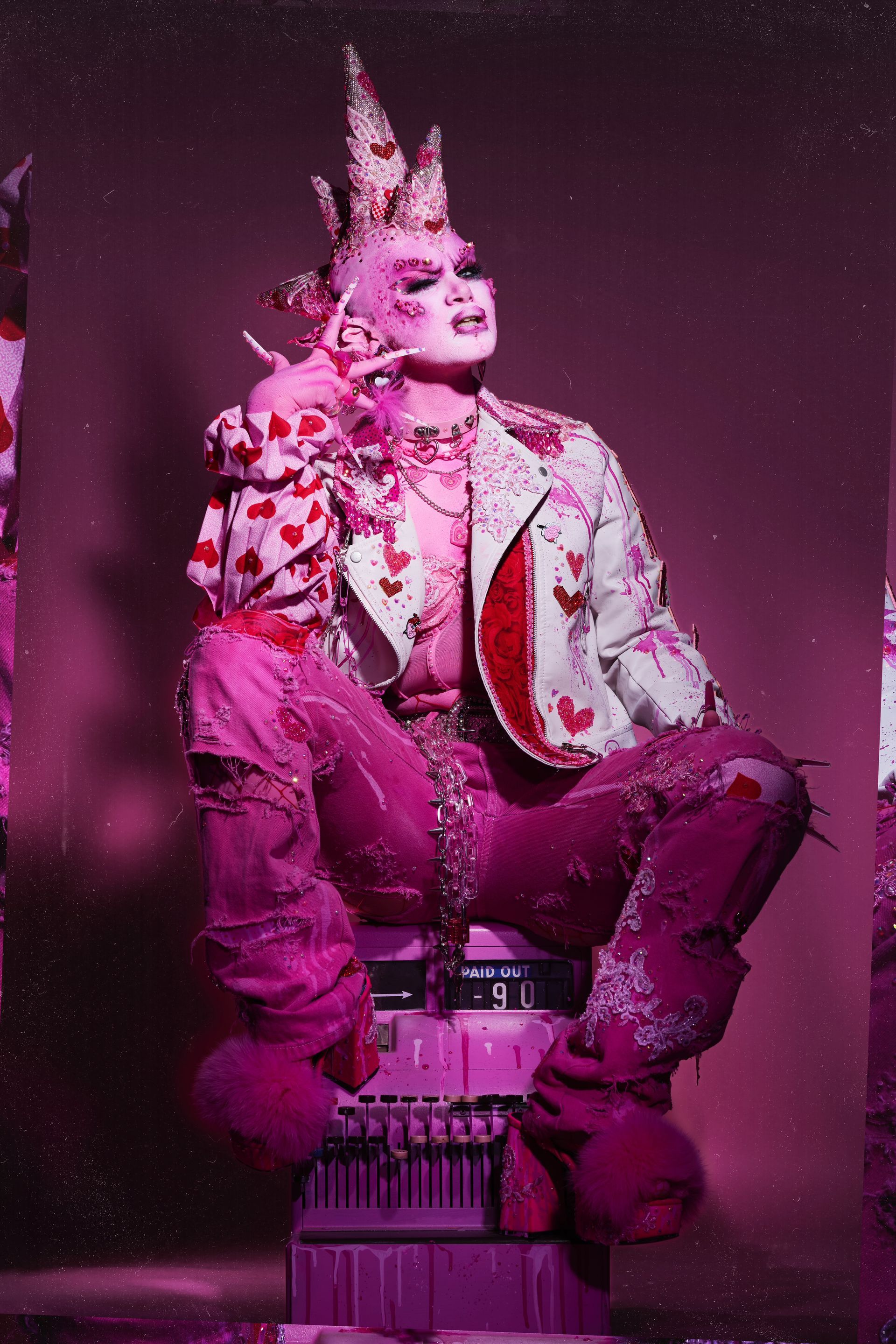 A man in a pink outfit is sitting on a box.