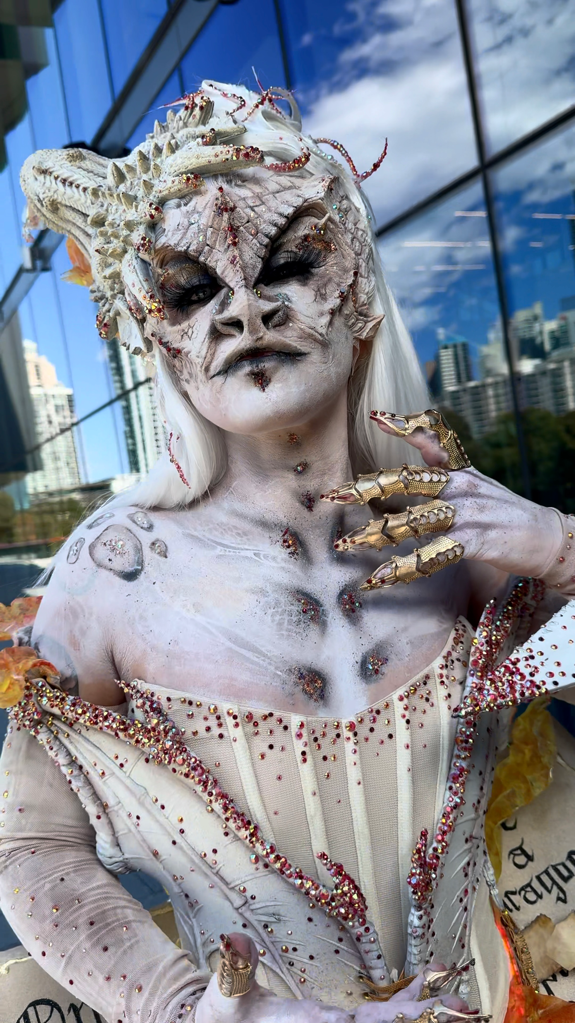 A woman is wearing a white dress and a white mask.