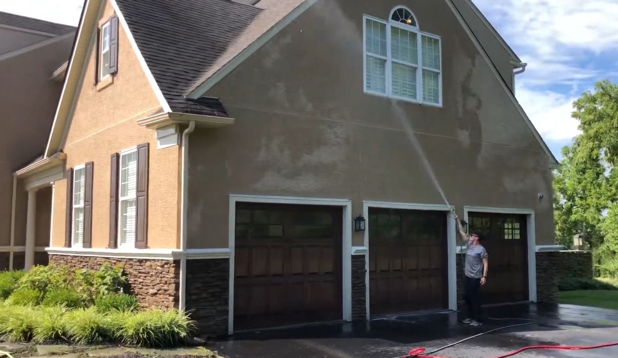 Man soft washing house in Dentsville, SC