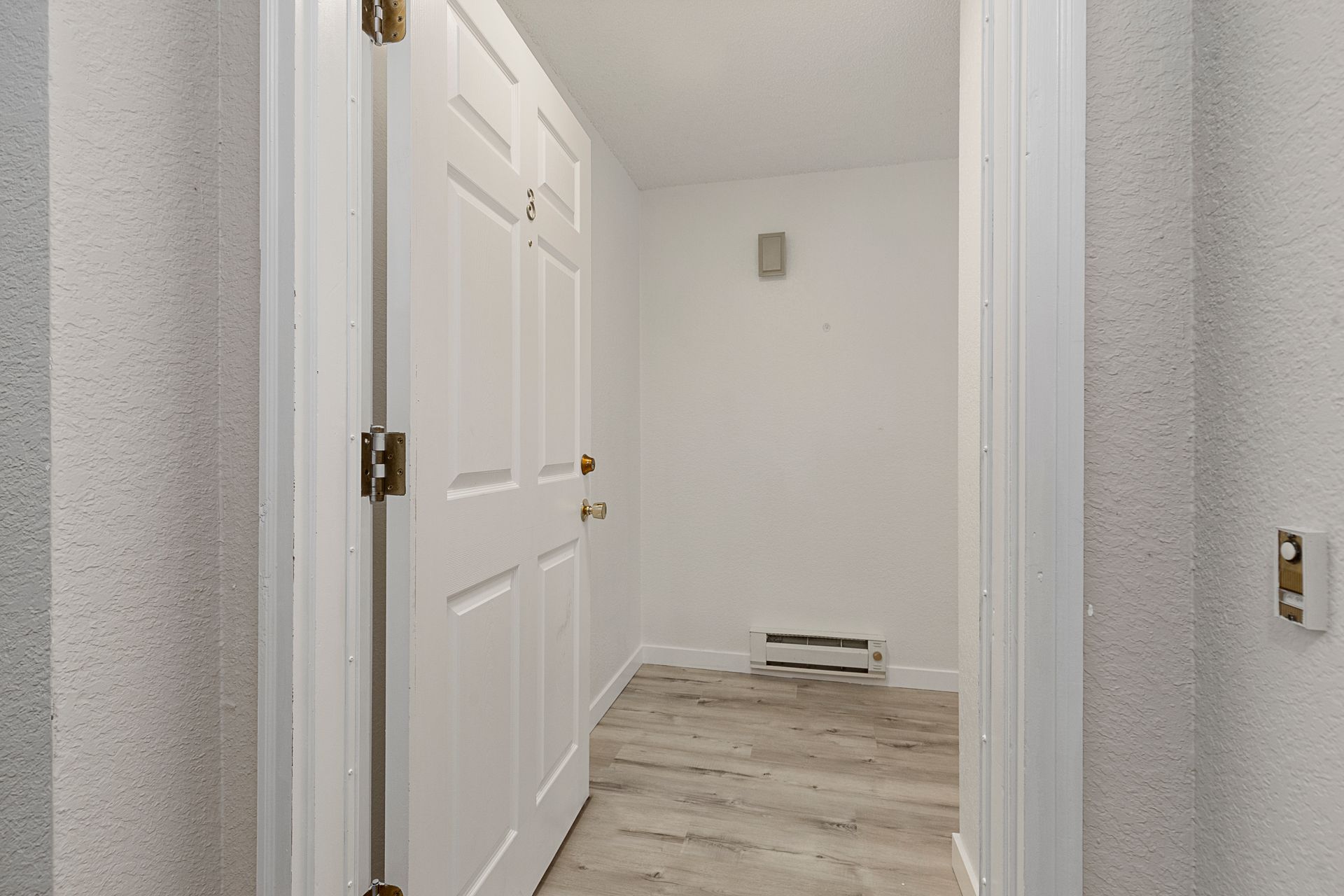 a hallway with white doors and wooden floors in a house .