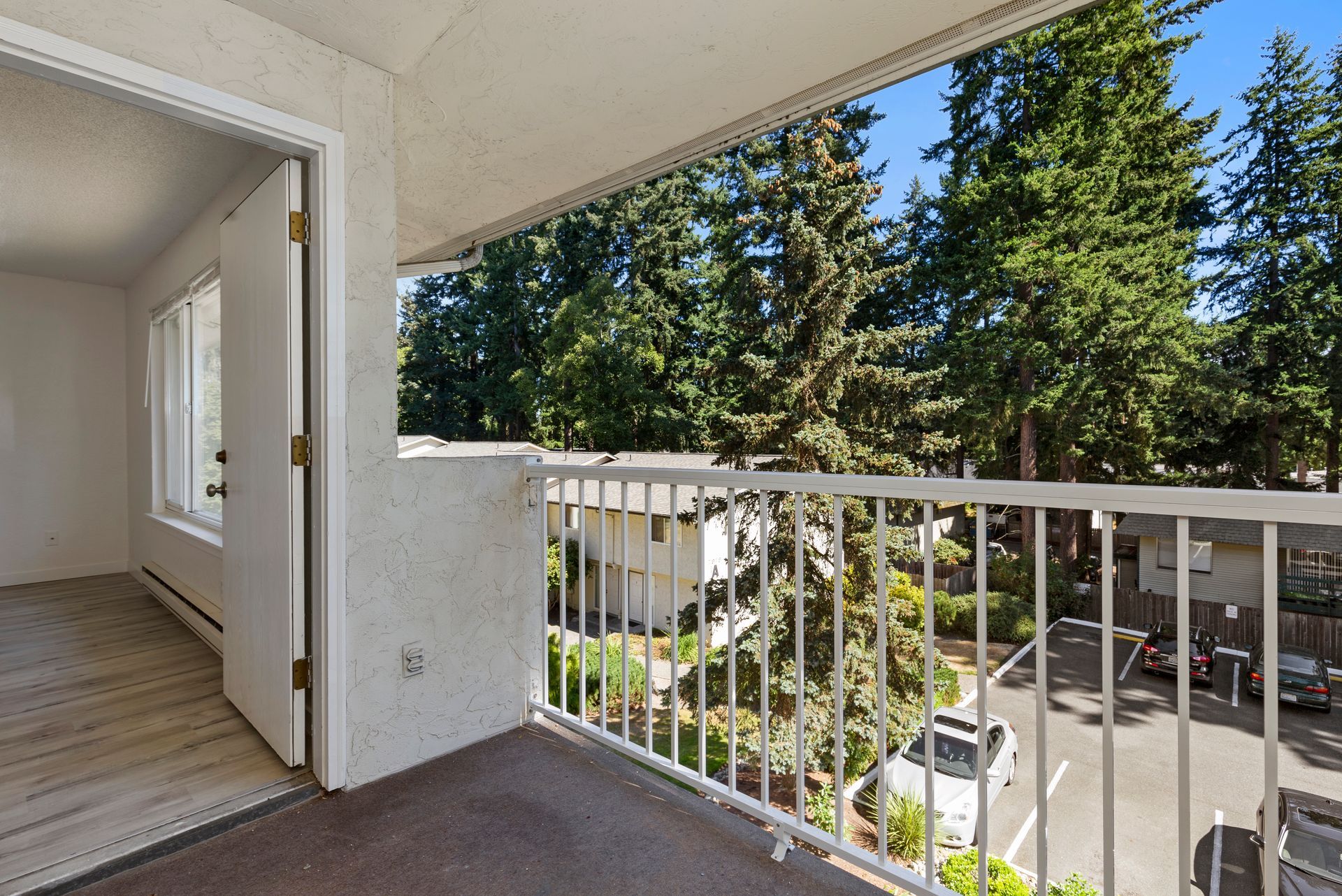 a balcony with a railing and trees in the background