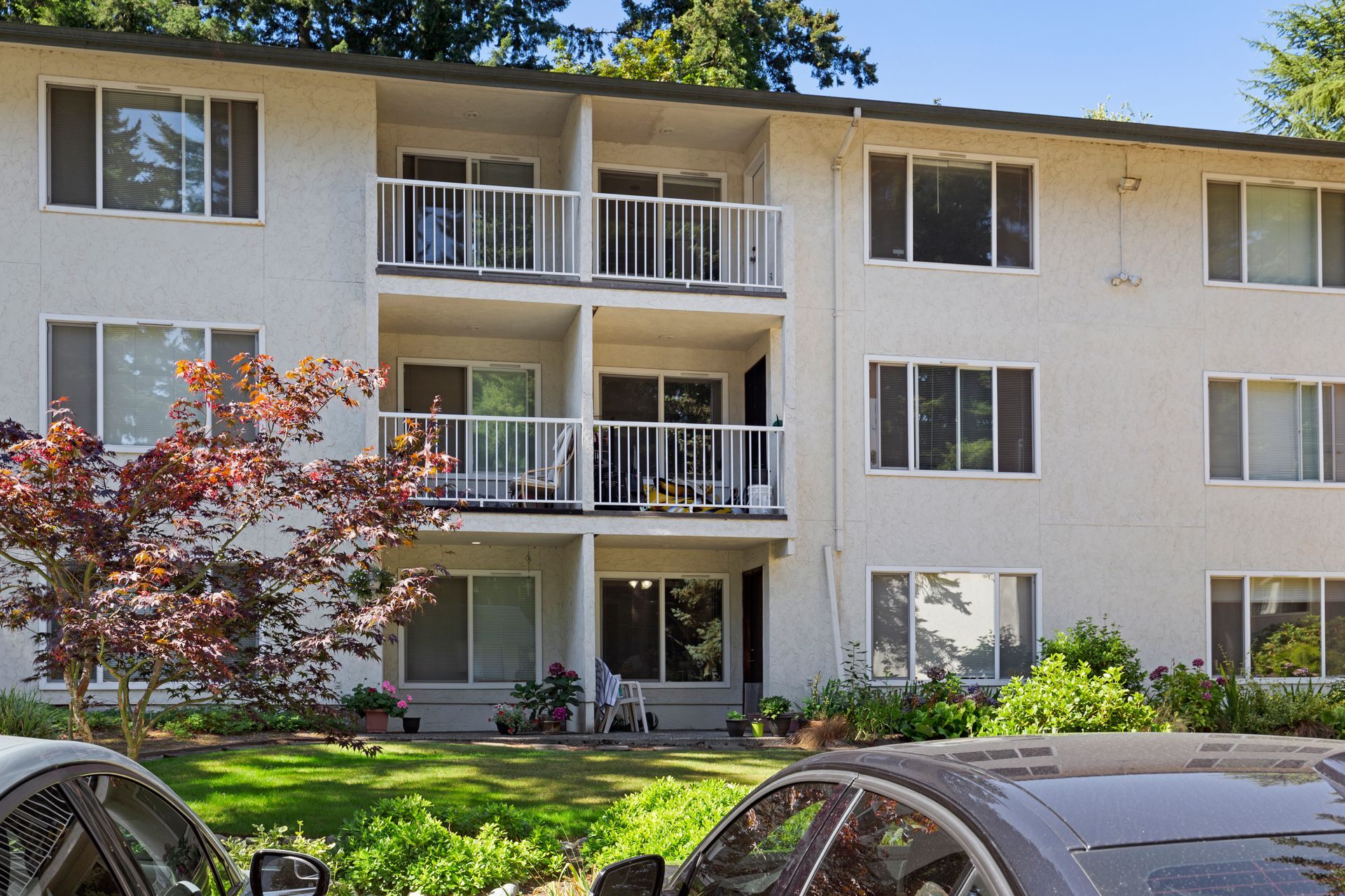 a white apartment building with cars parked in front of it