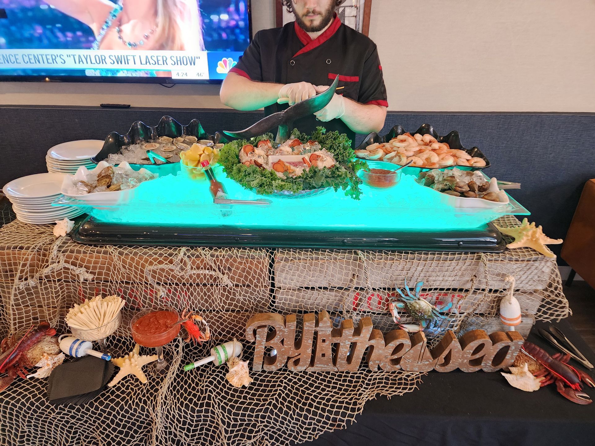 A man is cutting shrimp on a buffet table.