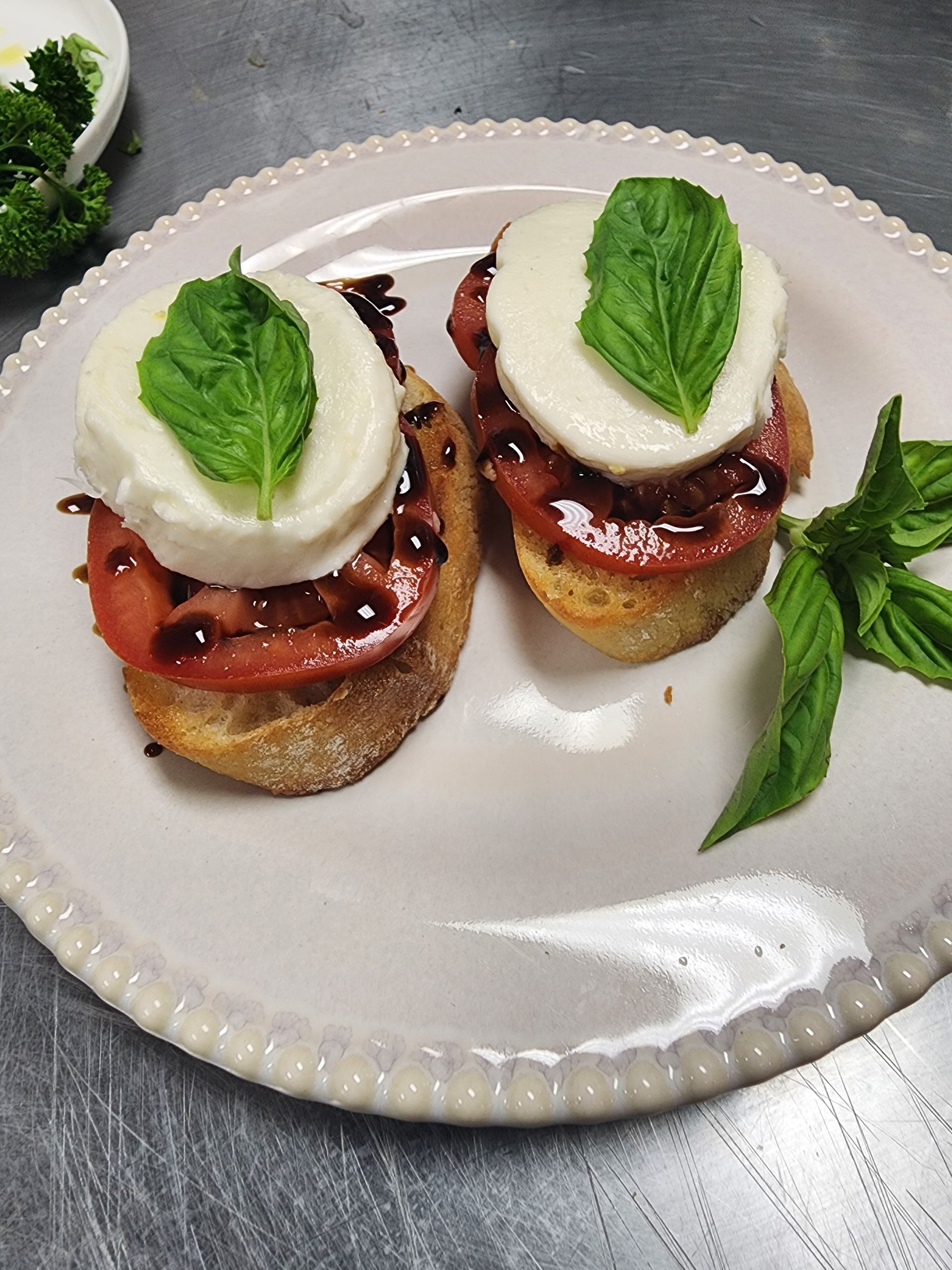 Two sandwiches with tomatoes and mozzarella on a white plate