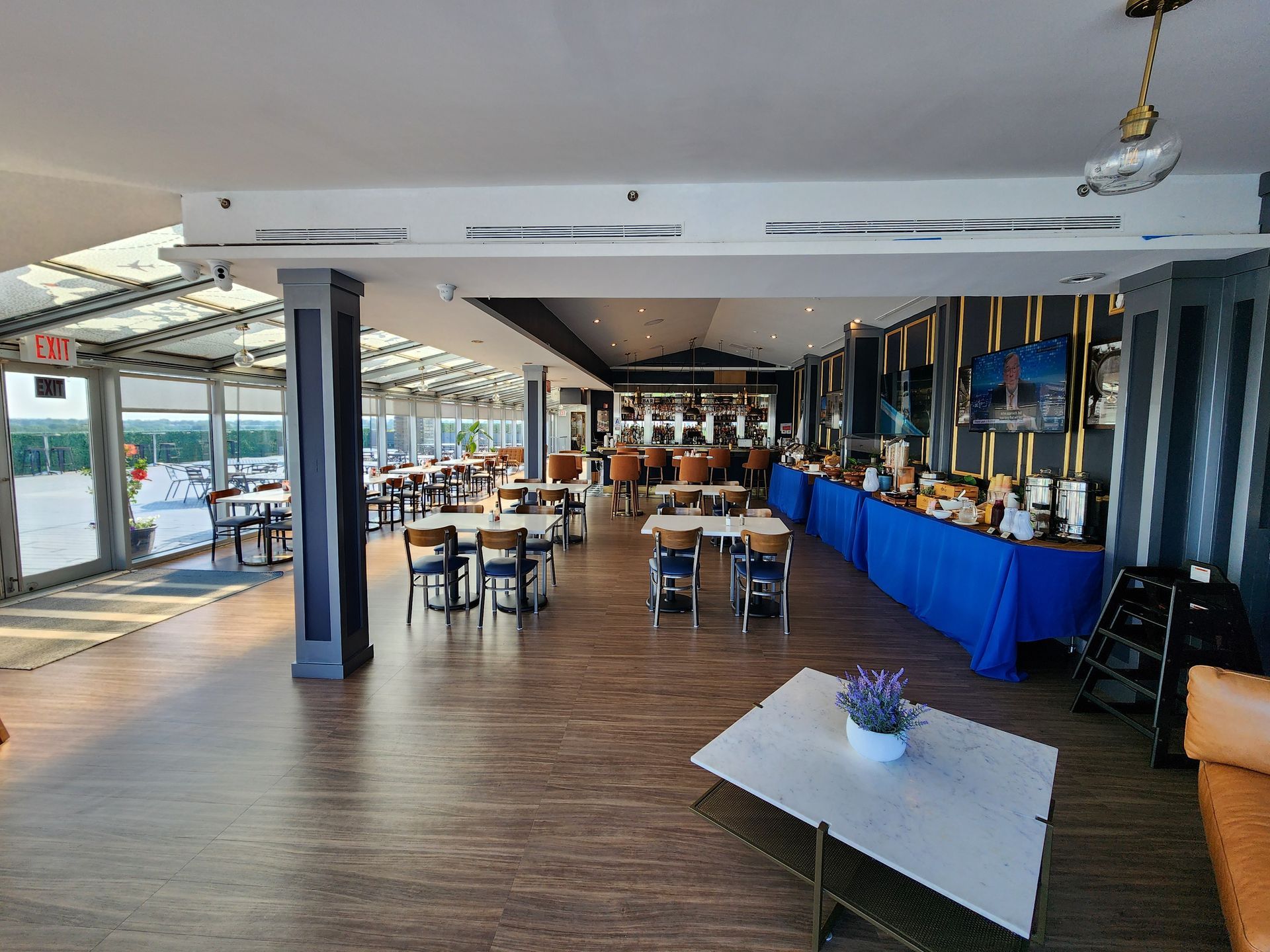 A large dining room with tables and chairs and a table with flowers on it.