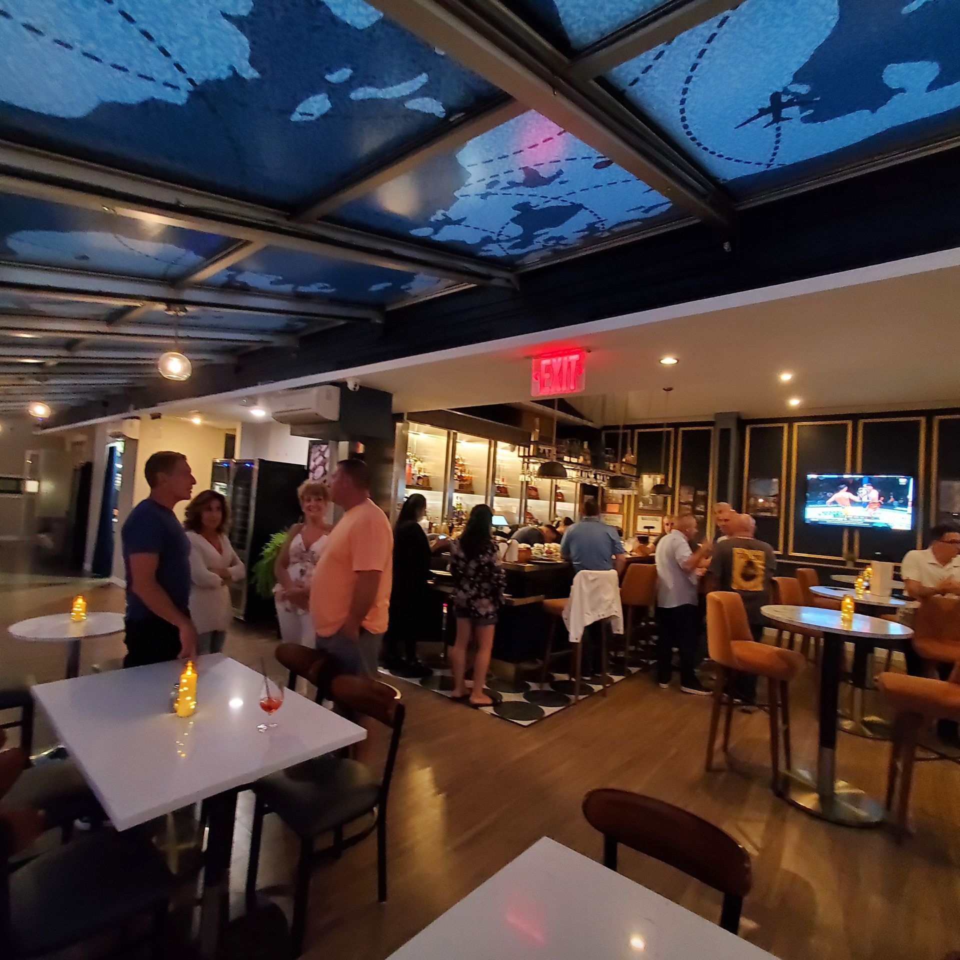 A restaurant with a red exit sign on the ceiling