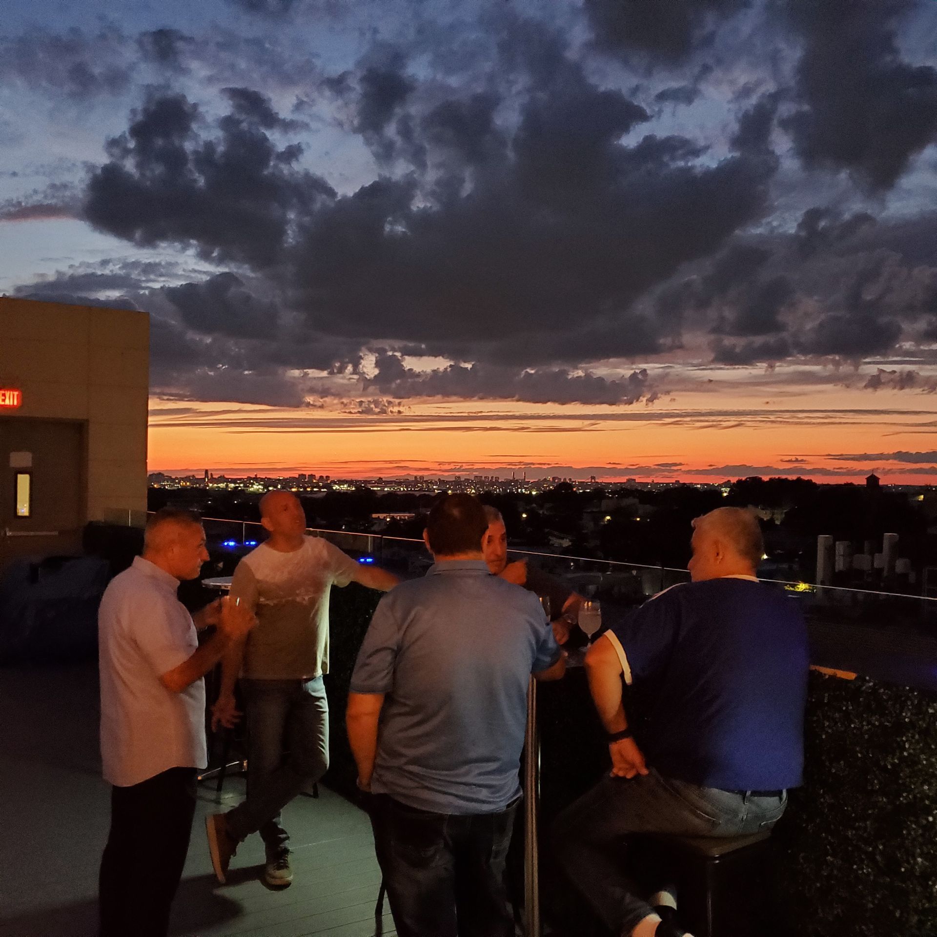 A group of men are standing in front of an exit sign