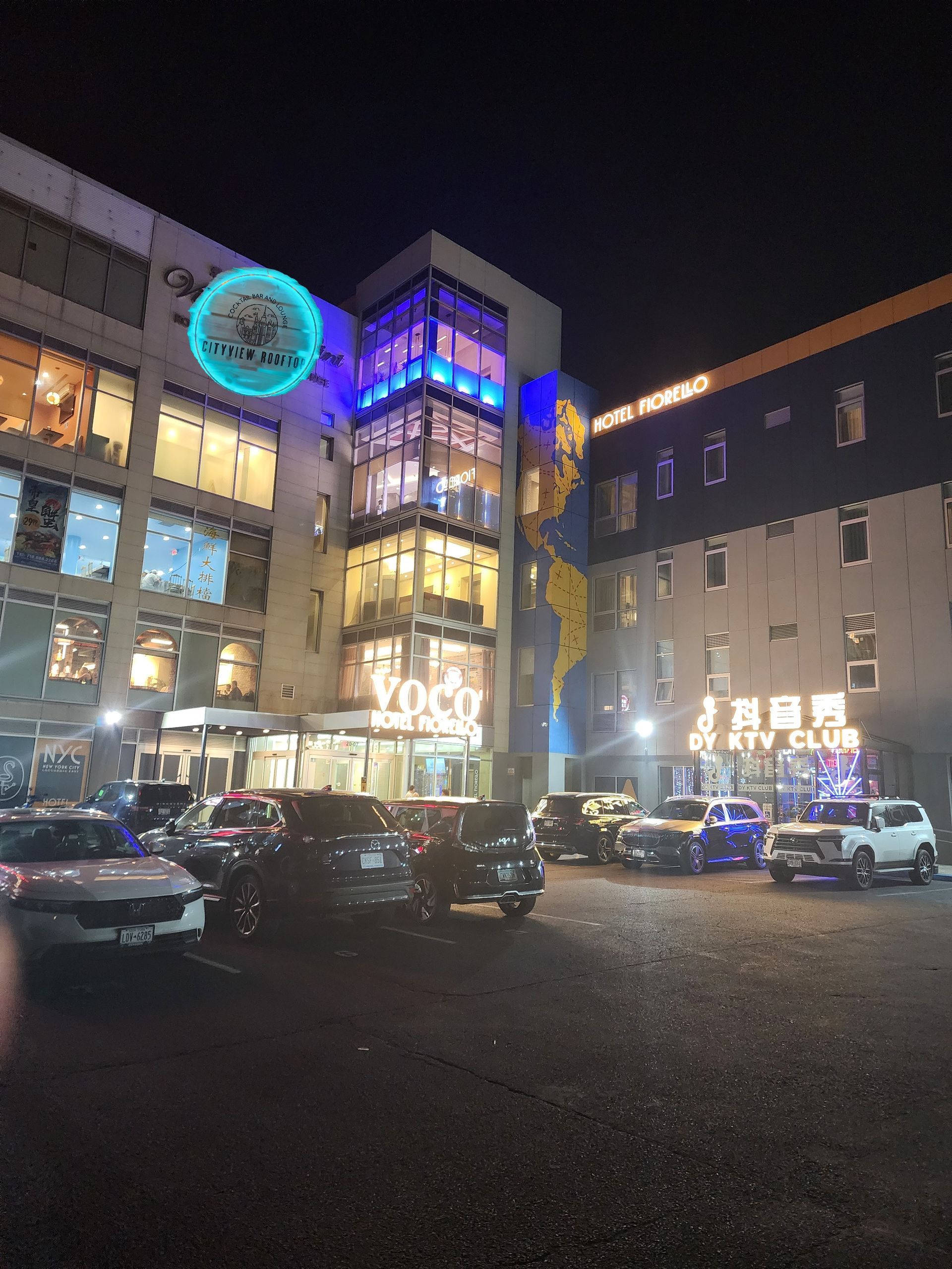 A large building with a lot of cars parked in front of it