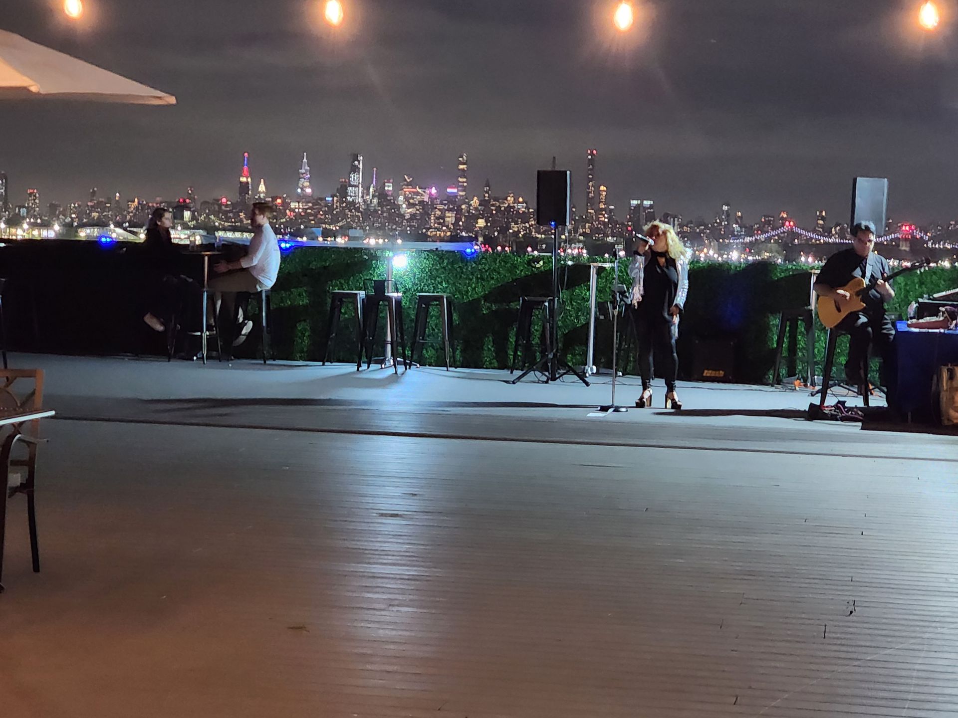A group of people are playing instruments on a stage at night.