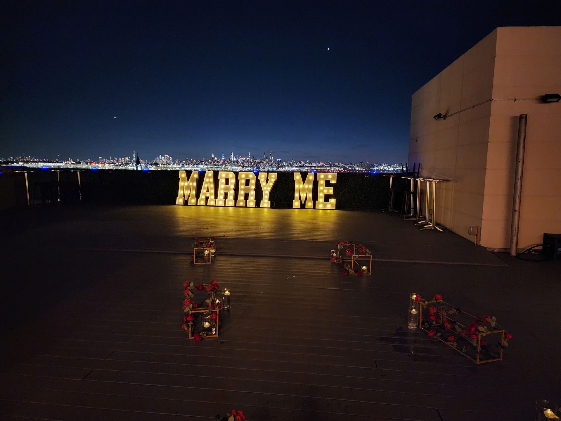 A large sign that says `` marry me '' is lit up at night.