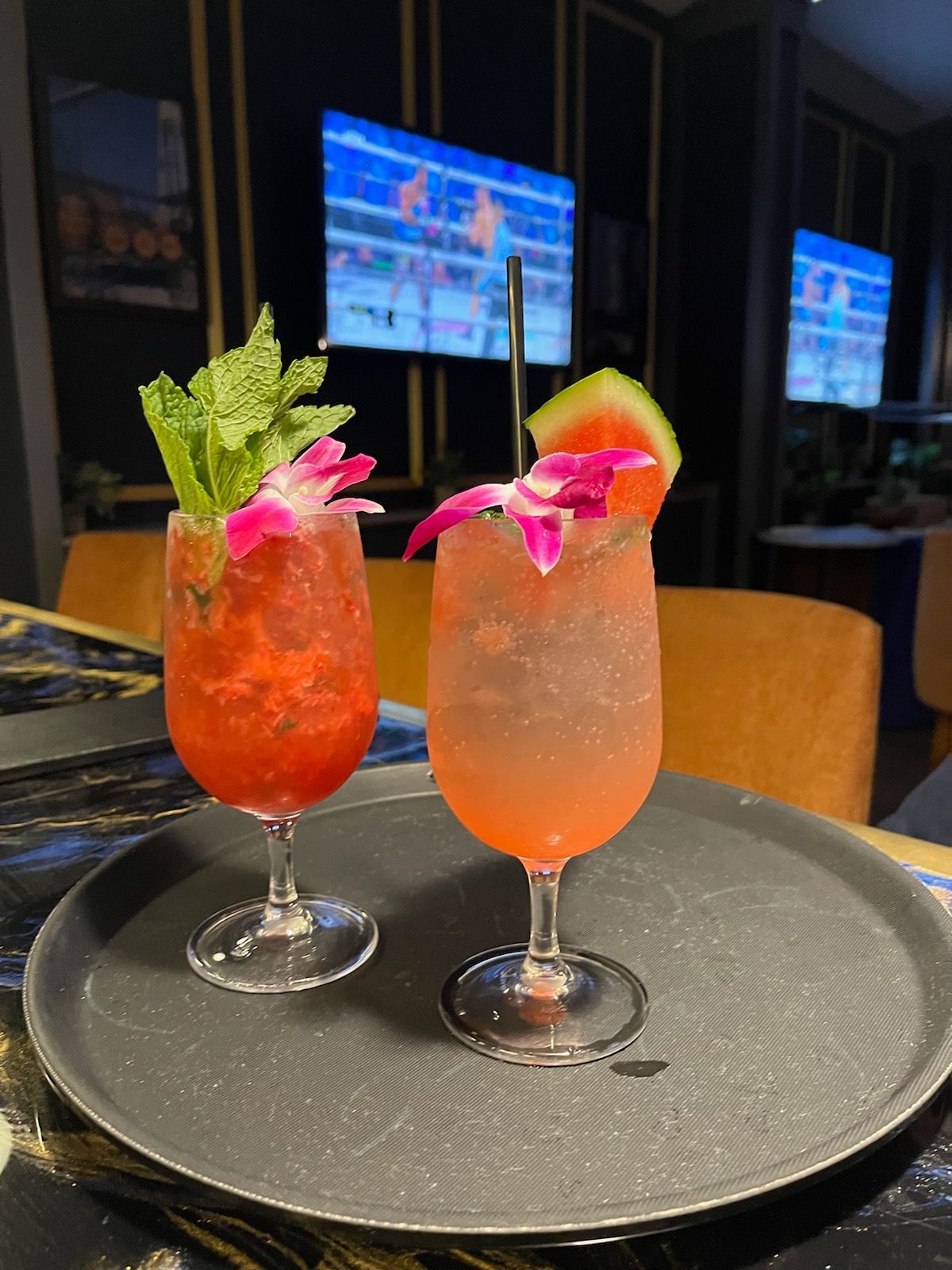 Two drinks are sitting on a tray on a table.