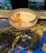 A close up of a cocktail in a glass on a table.