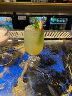 A close up of a drink in a glass on a table.