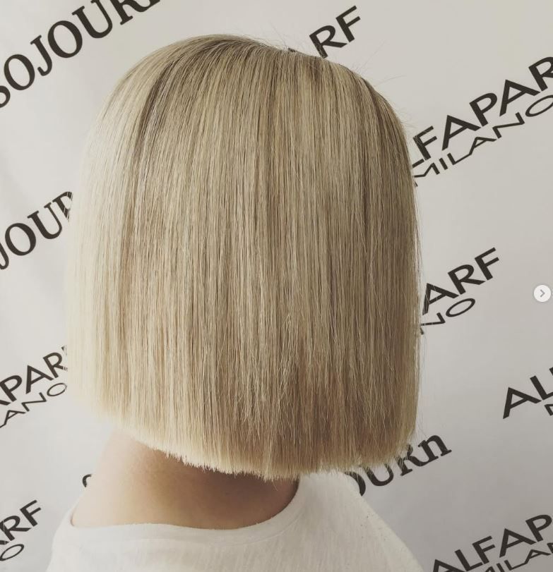 A woman is getting her hair cut in a salon.