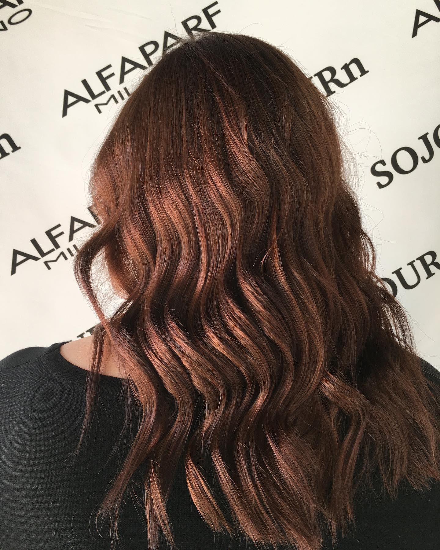 A woman with red hair is wearing a polka dot shirt.