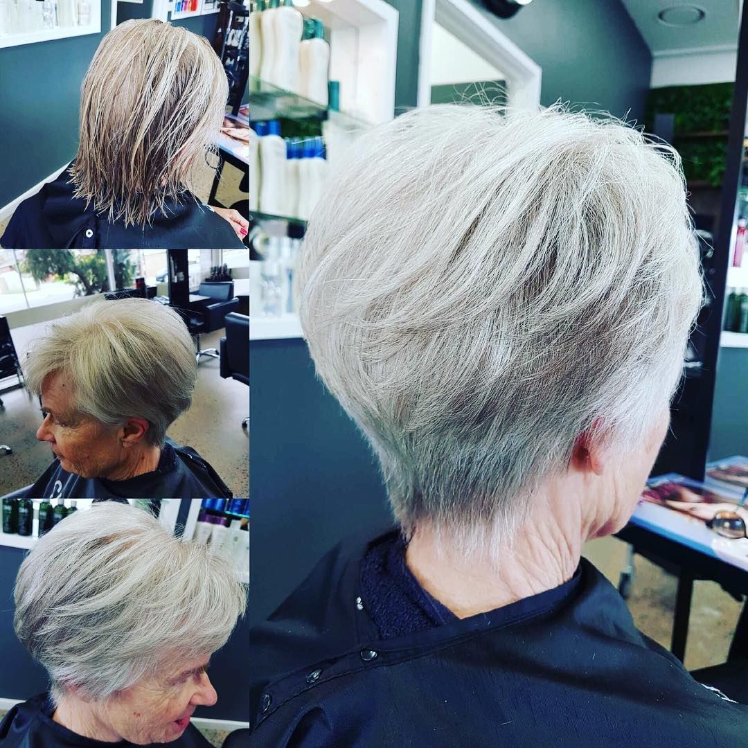 Three women in black dresses are standing next to a tree