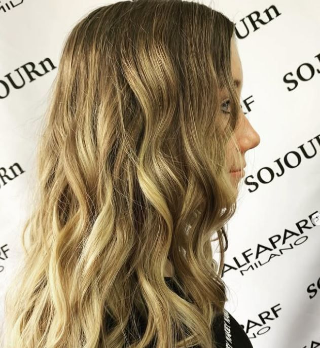 A woman is standing in front of a sign that says sojourn